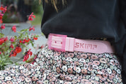 Light pink SKIMP Originale belt worn with a floral skirt