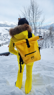 Yellow SKIMP Adventurer backpack worn in the snow