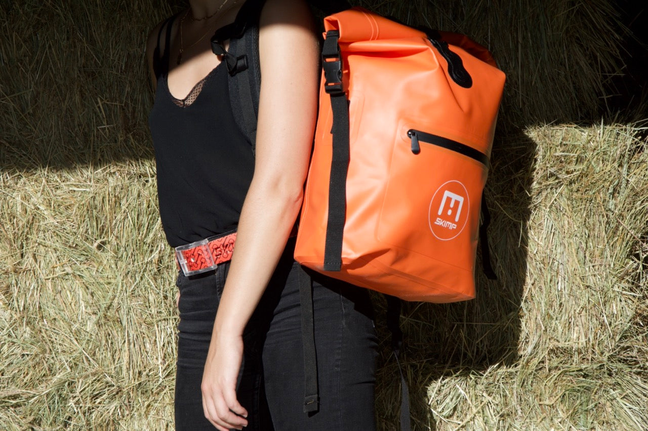 Orange SKIMP Adventurer backpack worn over the shoulder