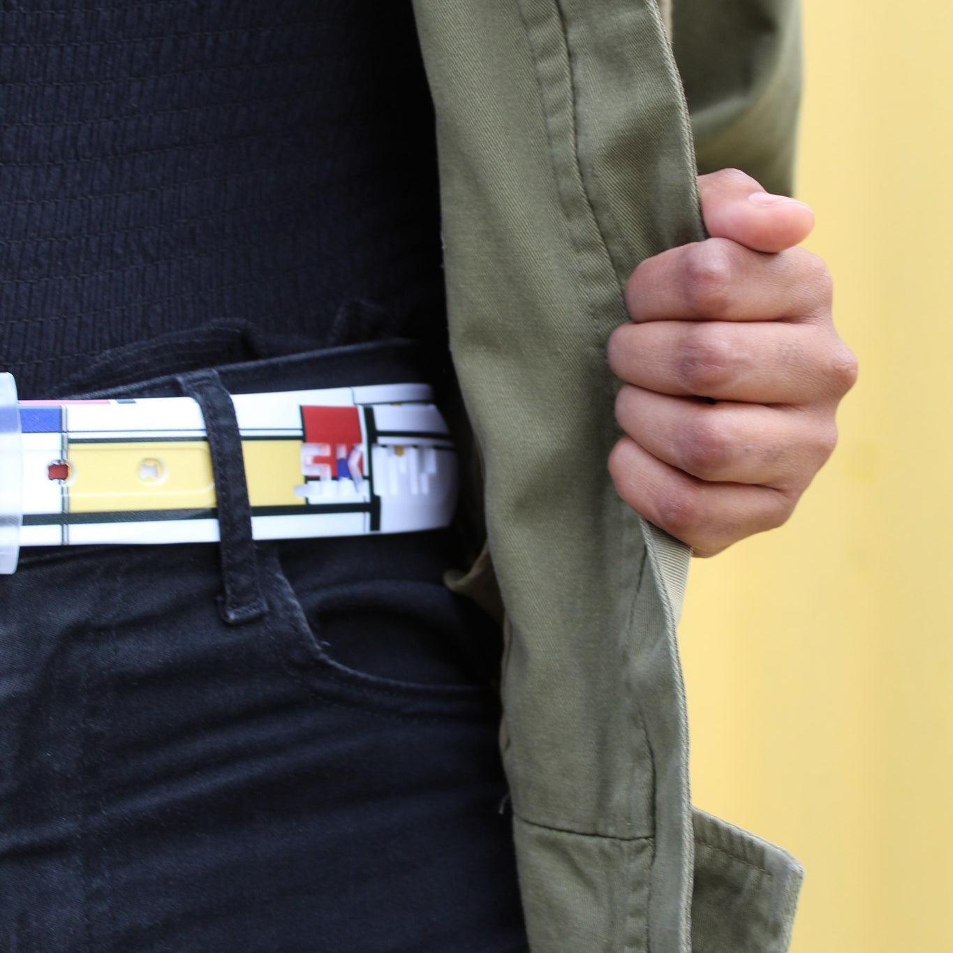 SKIMP Geometric Belt worn with black jeans and khaki jacket – metal-free waterproof printed belt