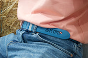 Close-up of the bright blue SKIMP Originale belt worn with jeans