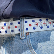 Close-up of the SKIMP Regatta Dot Belt with clear metal-free buckle on light denim