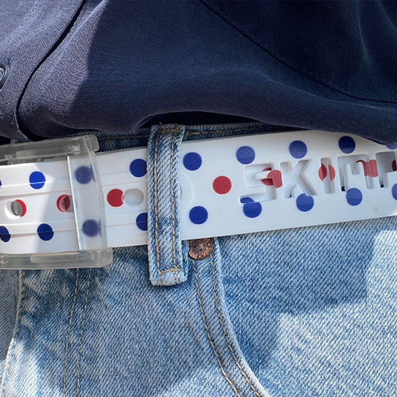 Close-up of the SKIMP Regatta Dot Belt with clear metal-free buckle on light denim